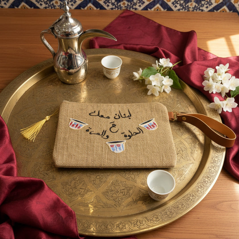Jute zip pouch stitched with a black Arabic saying between three small coffee cups
