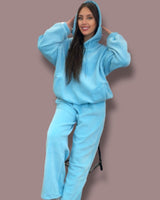 Person wearing a bold blue jogging set against a brown background