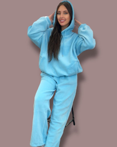 Person wearing a bold blue jogging set against a brown background