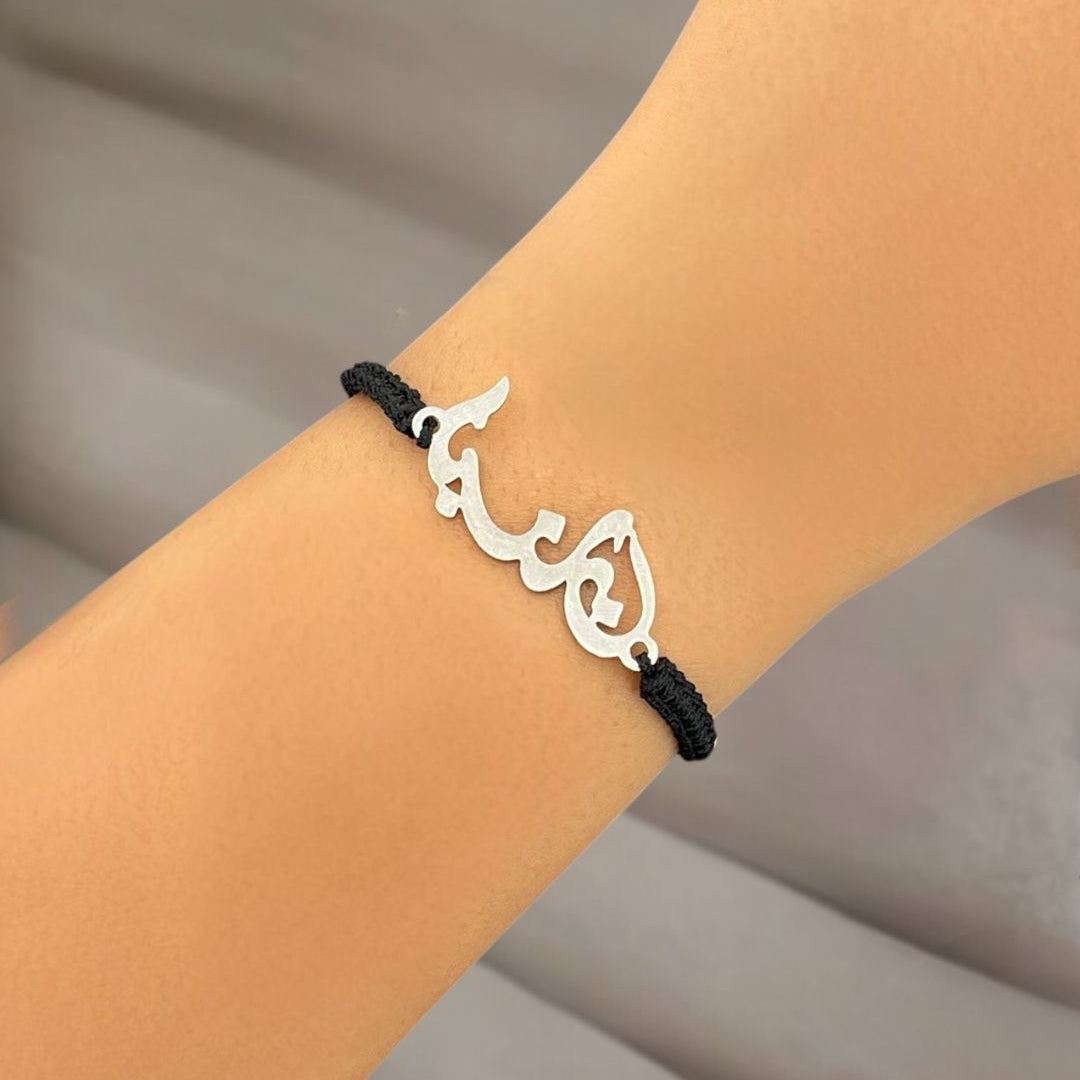 Silver Lebanon bracelet with Arabic calligraphy on a wrist against a neutral background