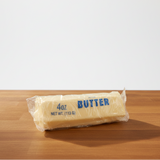 Packaged squishy butter on a wooden surface with a white background