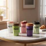 Set of colorful Coca-Cola tumblers on a table with a blurred indoor background