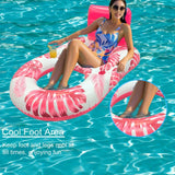 Woman lounging on a pink and white inflatable ring in a pool with a visible foot area