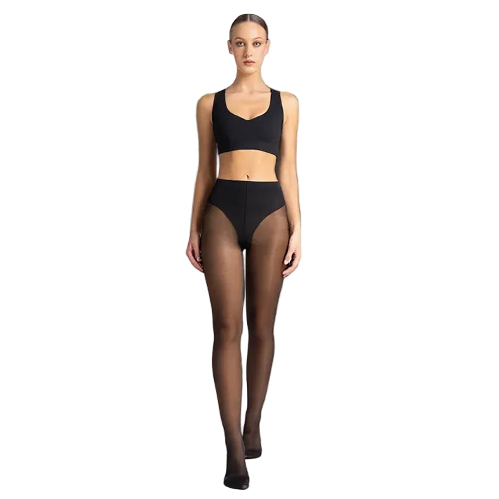 Woman wearing a black sports bra and sheer black tights on a white background
