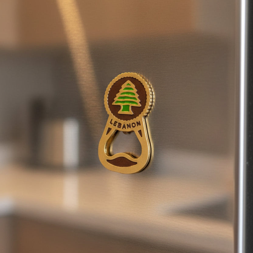 Gold cedar medallion joined to a bottle opener loop, held on a stainless fridge door