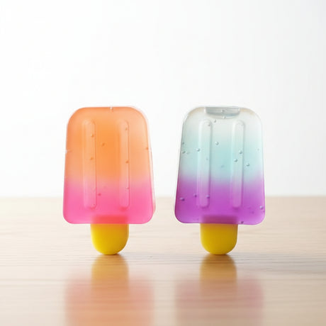 Two small ice creams with in clear plastic packaging on a textured surface.