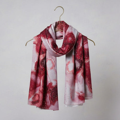 Red and white patterned scarf on a hanger against a plain background