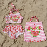 Children's swim set with pink watermelon design on the sand
