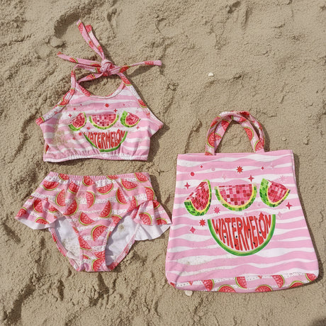 Children's swim set with pink watermelon design on the sand