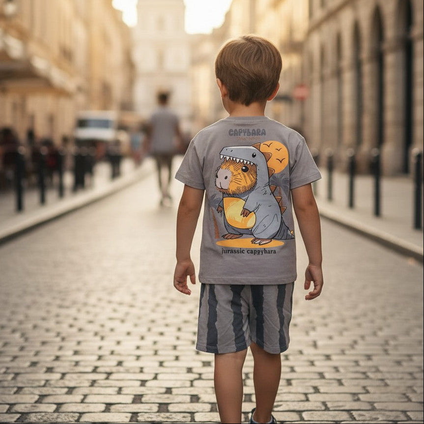 Child walking down a cobbled street in an urban setting with a cartoon t-shirt on