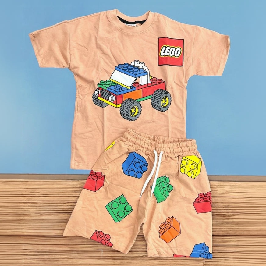 Beige boys two piece set, tee with a block truck graphic and brick print shorts laid flat