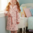 Young girl wearing a pink Hello Kitty robe in a bedroom