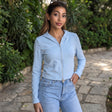 Pale sky blue slim zip hoodie in smooth stretch fabric, cropped at the waist of blue jeans