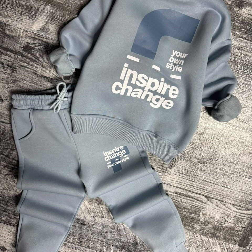 Light blue sweatshirt laid flat showing the bold back print and joggers