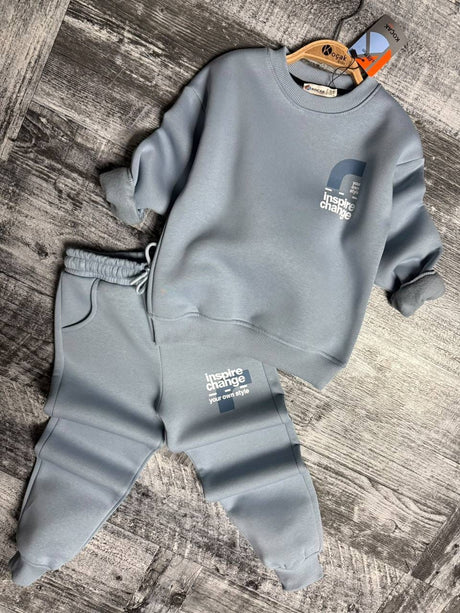 Light blue sweatshirt and cuffed joggers laid flat on a wooden floor