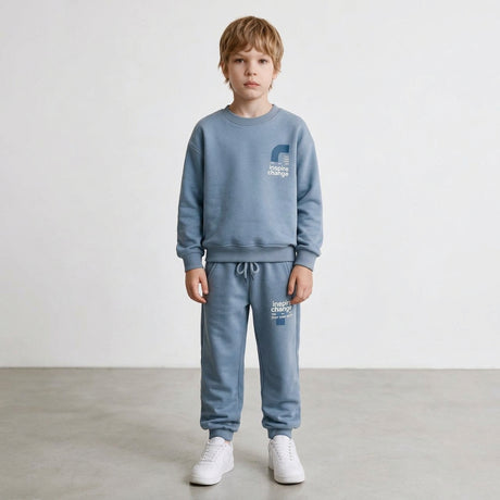 Boy in a light blue crew neck sweatshirt and drawstring joggers