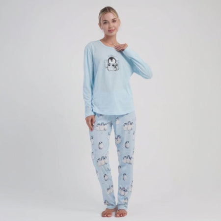 Woman wearing a light blue cotton pyjama set with penguin design on a white background