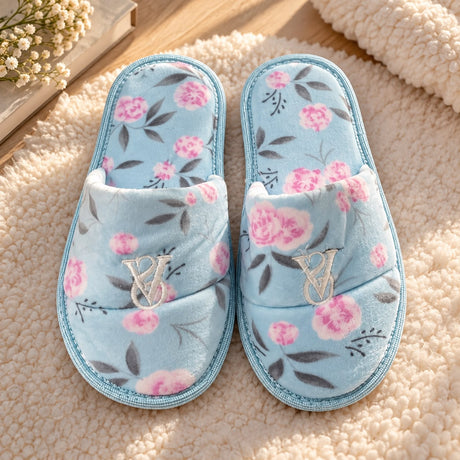 Light blue open toe slippers with pink roses and grey leaves on a cream knit throw