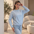 Light blue pointelle knit crew neck sweater, hand at hair