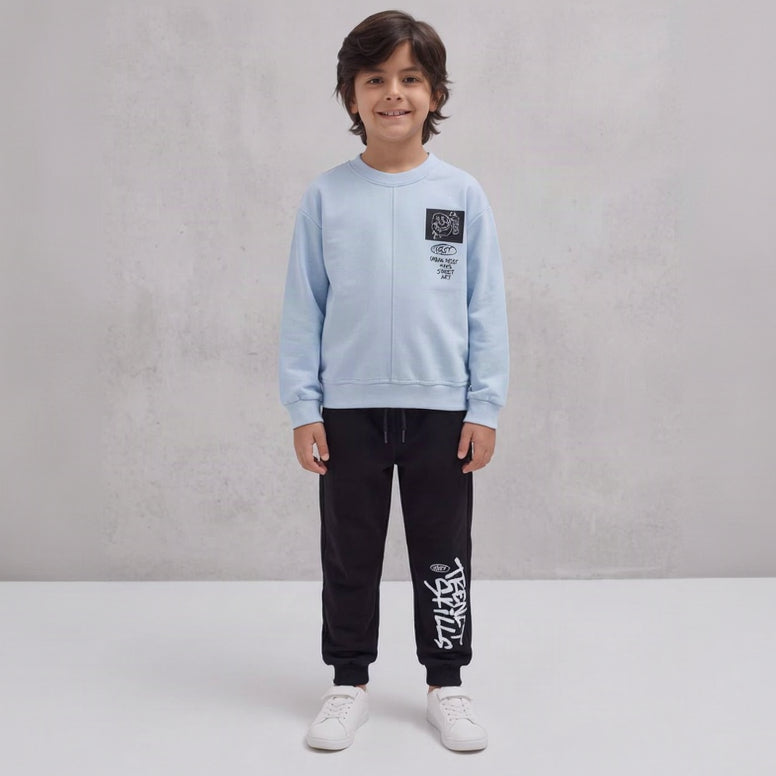 Smiling boy in a light blue street art sweatshirt and black graffiti joggers