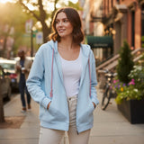 Light blue zip hoodie worn open over a white tee with hands in the side pockets
