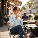 Light blue teddy bear sweatshirt worn at an outdoor cafe table