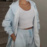 Close view of the pale blue velour hoodie worn open over a white tank