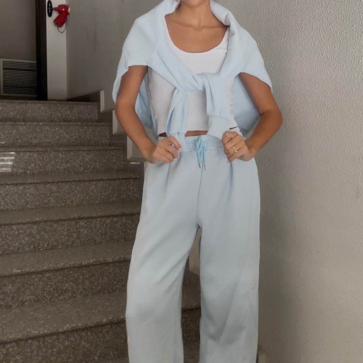 Wide leg velour trousers with a drawstring waist, hands on hips