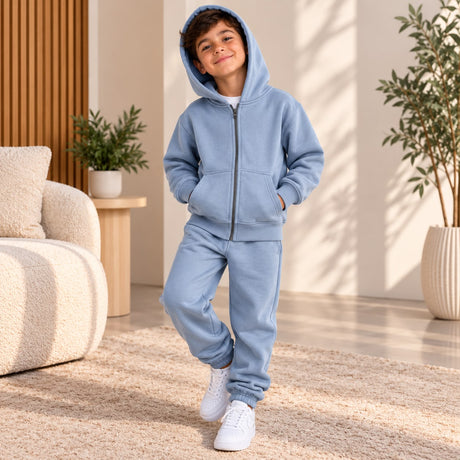Boy in a light blue zip up hoodie with the hood up and matching blue joggers