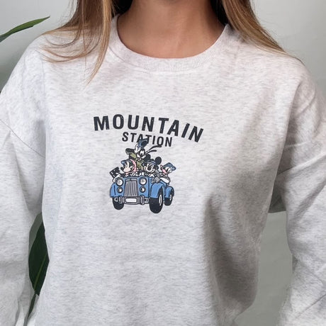 Close up of the vintage car graphic and dark lettering on a light grey sweatshirt