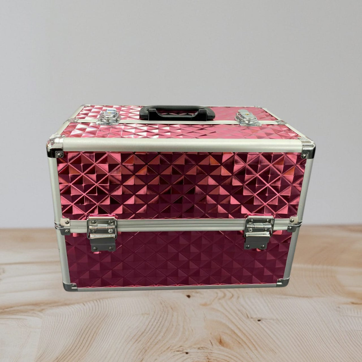 Pink studded aluminium vanity case closed with a black handle and silver clasps