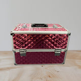Pink studded aluminium vanity case closed with a black handle and silver clasps