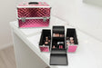 Two pink studded aluminium vanity cases, one open with fold out trays of makeup