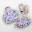 Light purple floral cosmetics bags with bottles on a light background