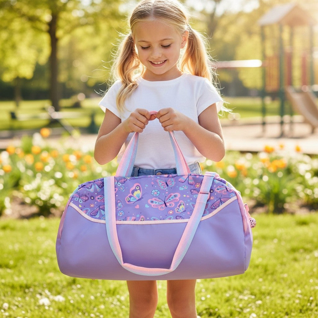 Girl holding a lilac kids duffle bag with a butterfly print panel and pastel striped handles