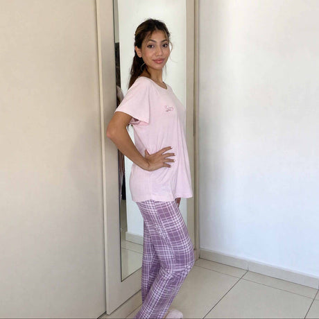 Side view of a soft pink sleepwear top over mauve checked trousers
