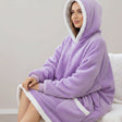 Ribbed cuffs and a broad white sherpa border round the hood, hem and pocket of a lilac blanket