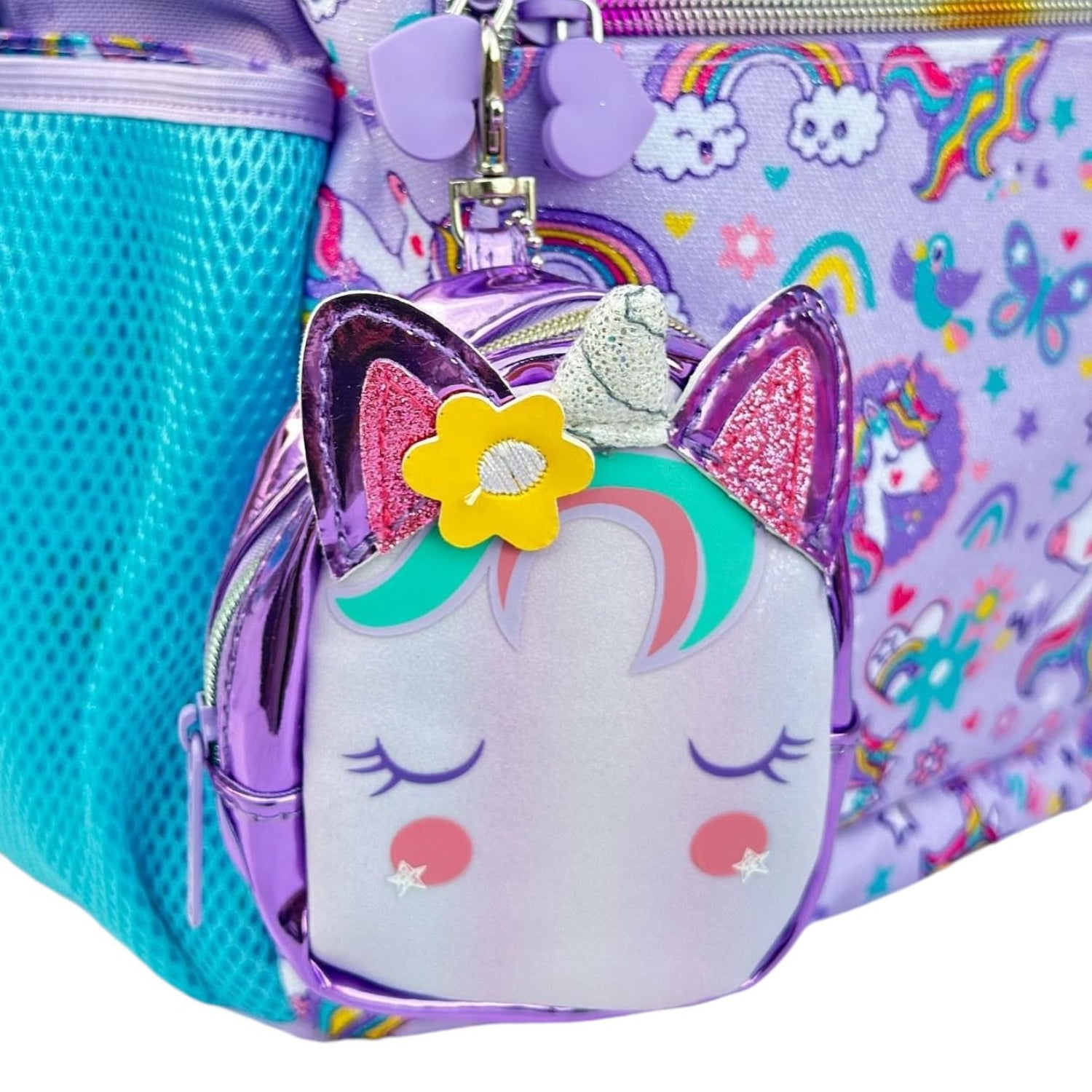 Mini unicorn coin pouch with glitter ears clipped to the backpack