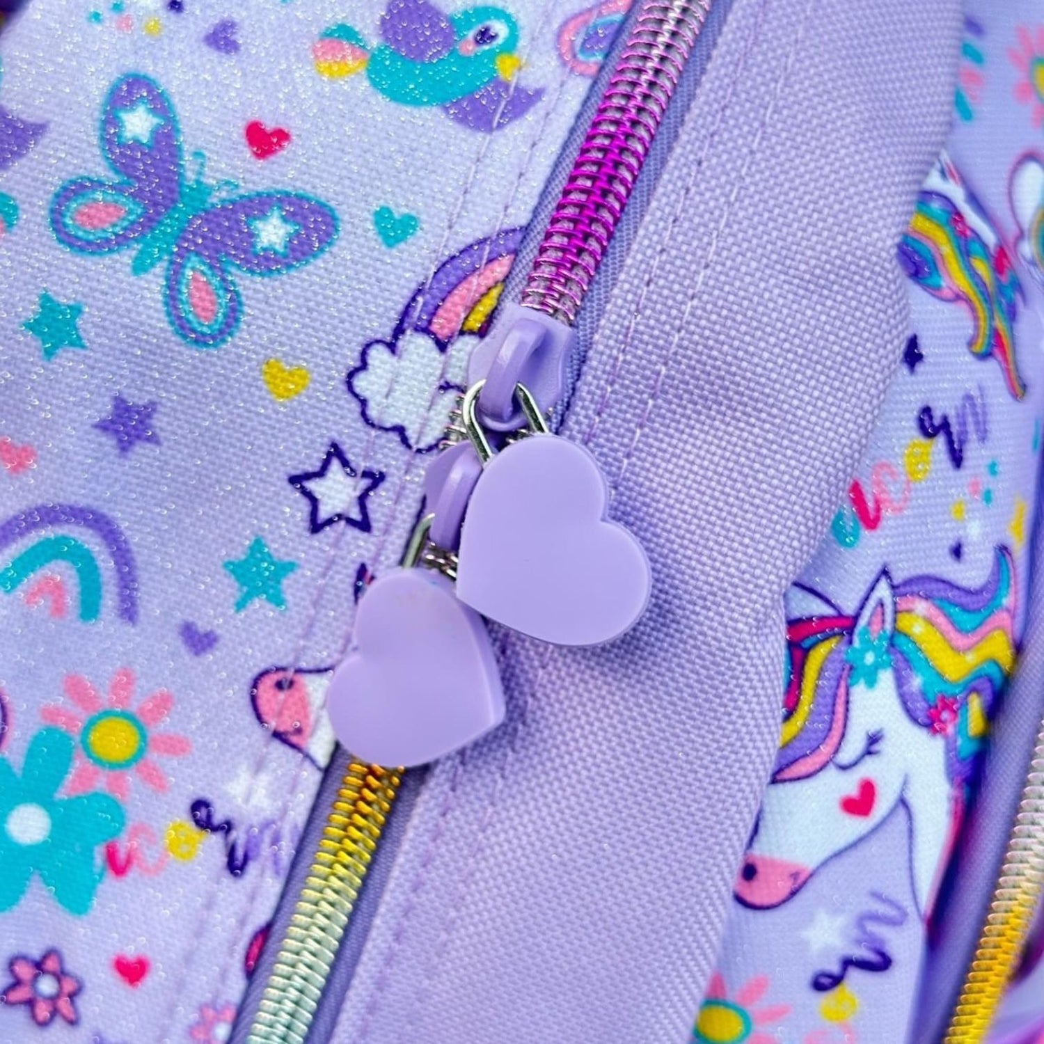 Heart shaped zip pulls and rainbow zips on the unicorn print fabric