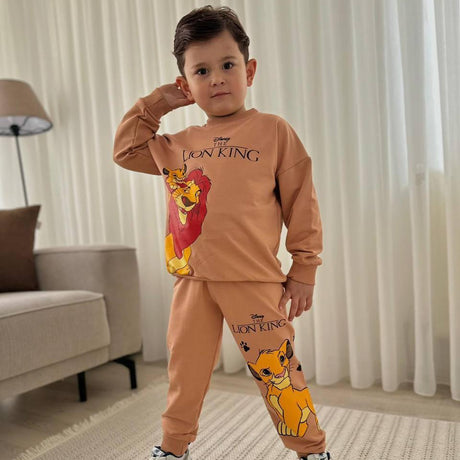 Boy posing indoors in a tan two piece long sleeve sweatshirt and joggers with a lion graphic