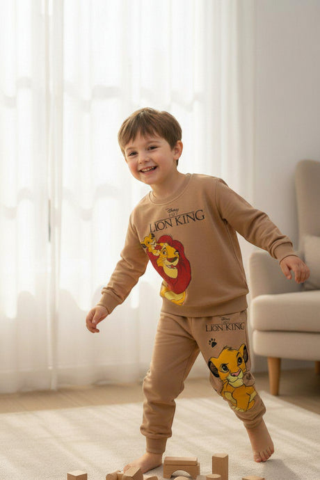 Smiling boy in a camel Lion King sweatshirt and matching jogger set with Simba and Mufasa print