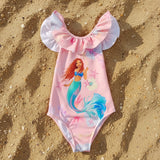 Pink mermaid-themed swimsuit with ruffled sleeves on the sand