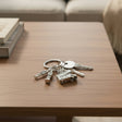 London keychain with Big Ben, red bus, and Royal Guard charms on a table