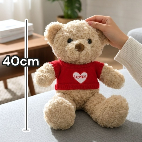 Adult hand resting on a cream jumper bear seated on a grey living room ottoman