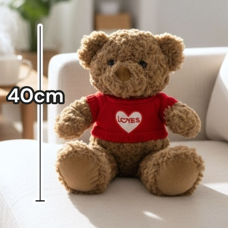 Golden brown teddy alone on a bright cream sofa in daylight, marked 40cm