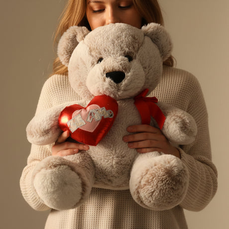 Woman in a cream jumper carrying the taupe bear in both arms