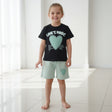 Girl in a black heart print tee and mint green shorts