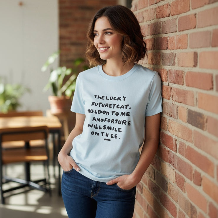 Light blue slogan tee worn against an exposed brick wall