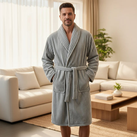 Man wearing a grey ribbed bathrobe in a bright living room