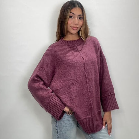 Magenta pink oversized knit top with a front seam and wide ribbed cuffs
